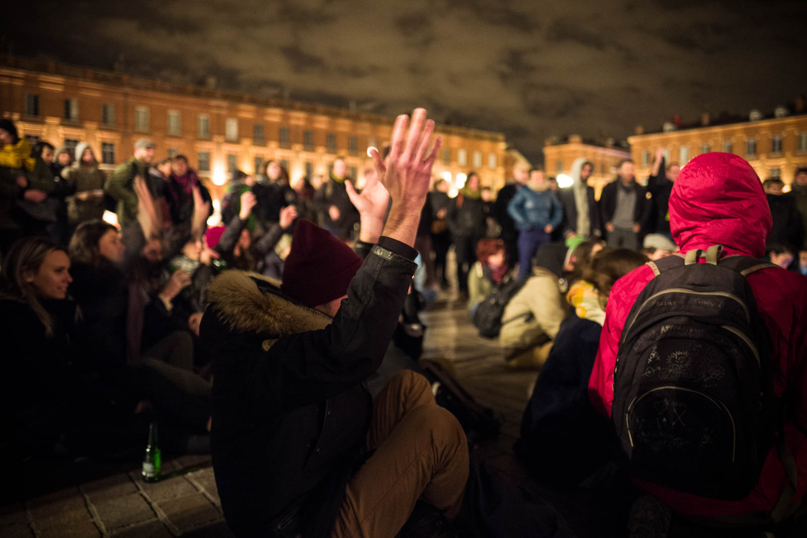 Un homme léve les mains en signe d'approbation lors du rassemblement NUIT DEBOUT sur la place du Capitole. Depuis le 31 mars des personnes se sont installées sur différentes grandes places dans des villes de l'hexagone la nuit.  Ces rassemblements pacifiques, appellés NUIT DEBOUT sont ouverts et populaires, ils visent à réinvestir l’espace public pour échanger, débattre et construire, la Place du Capitole est occupée depuis le 5 avril. 8/04/2016, Toulouse-France.