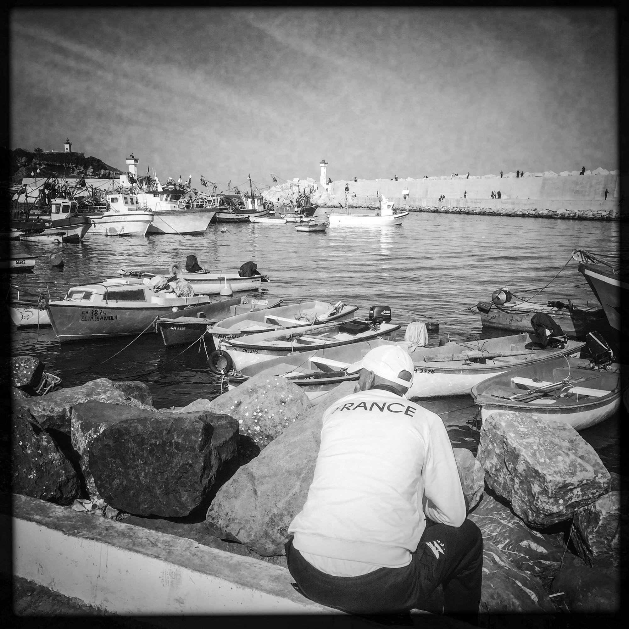 Un homme assis dans le petit port de Tipaza. 31/06/2016, Tipaza-ALGER.